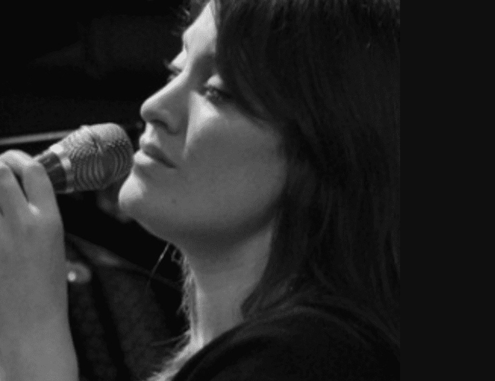 A black and white image of a jazz singer holding a mic